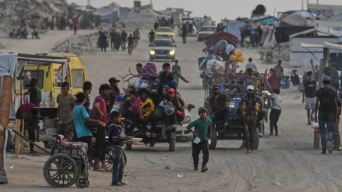 Displaced Palestinians travel in Gaza City on 10 August