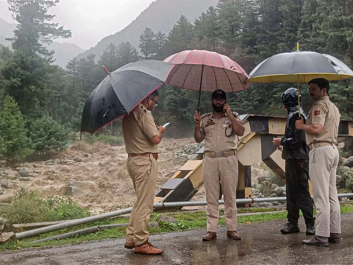 Police near a stream in Pahalgam with the water level rising after the Kishtwar cloudburst