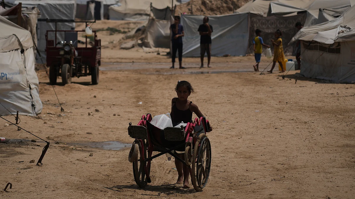A Palestinian girl pushes a cart in Khan Younis on 13 August