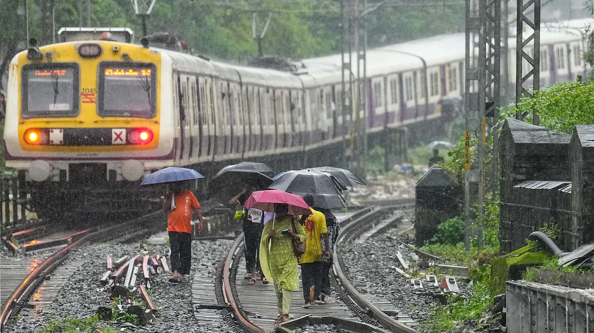 with train services hit, commuters walk along rail tracks. (Photo: PTI)