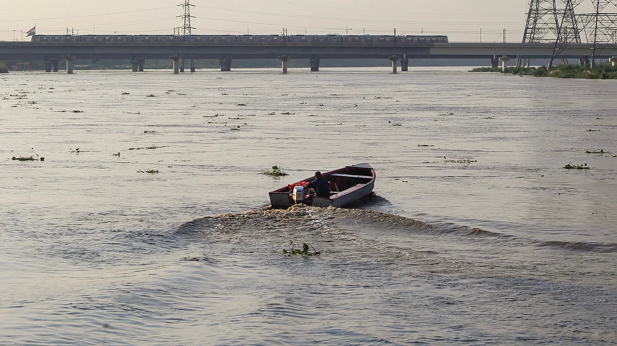 A man rides a motorboat on the swollen Yamuna river in New Delhi on 18 August