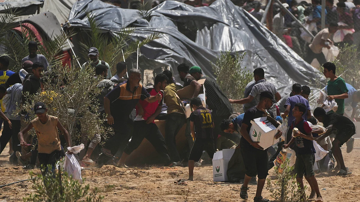 Palestinians rush to collect aid packages from the UAE airdropped into Deir al-Balah