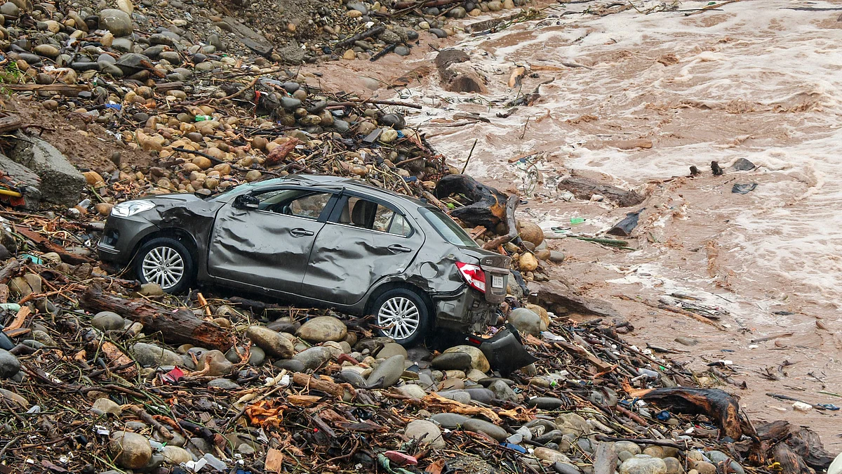 A car lies damaged in debris after a portion of a bridge was washed away in Tawi river in Jammu.