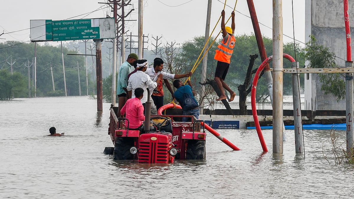 Electricians at work at a flooded area in Prayagraj