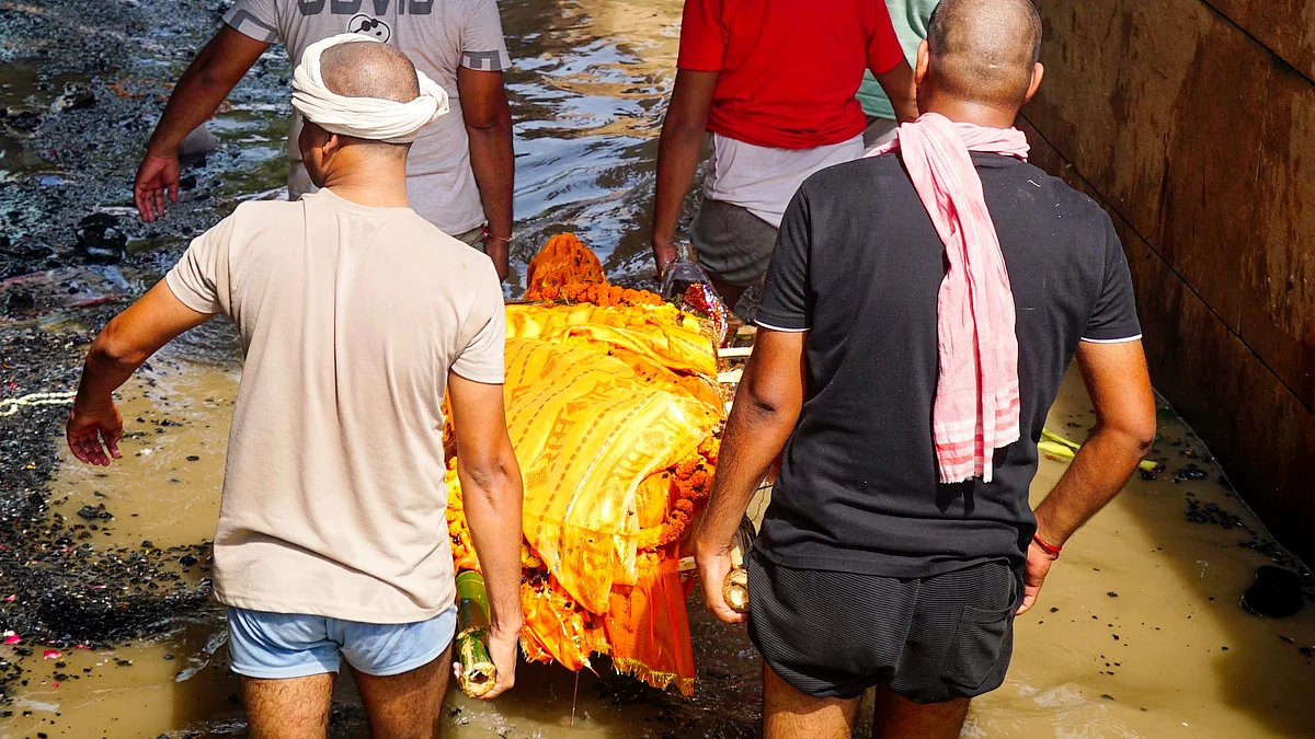 People carry the mortal remains of a relative through a flooded Manikarnika ghat area, 27 Aug