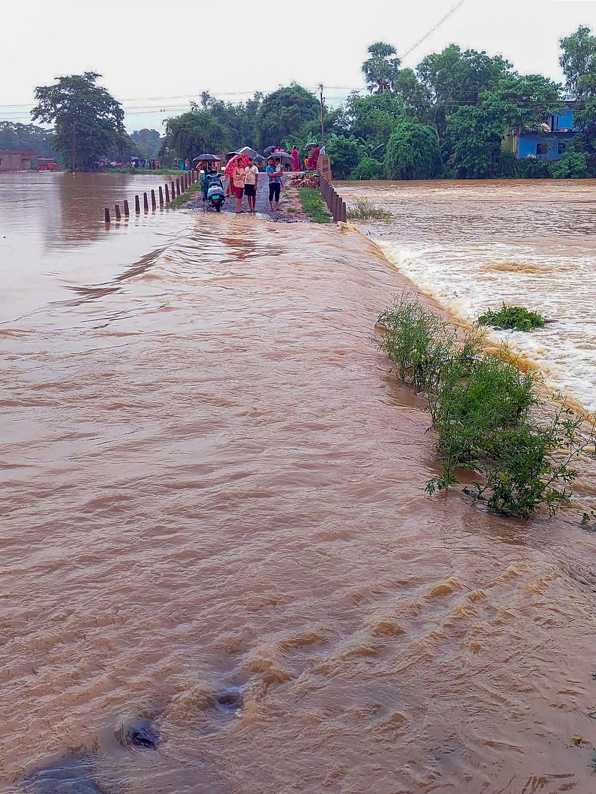 Stranded residents stand near the Subarnarekha river in Balasore. (photo: PTI)