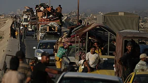 Displaced Palestinians move with their belongings near Wadi Gaza on 30 August
