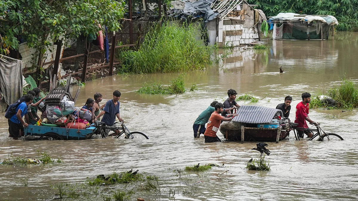 Commuters wade through a flooded street in New Delhi