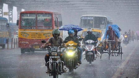 Vehicles navigate through steady showers on Kolkata’s iconic Howrah Bridge