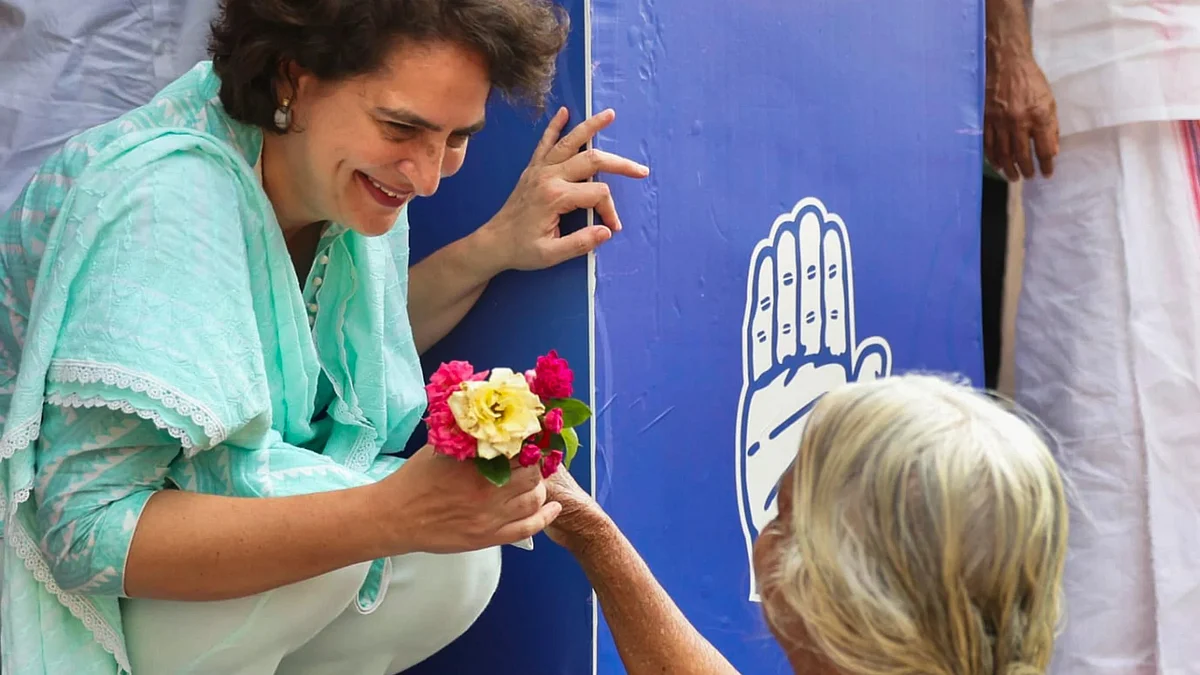 Priyanka Gandhi Vadra accepts flowers from a senior supporter while campaigning in Wayanad