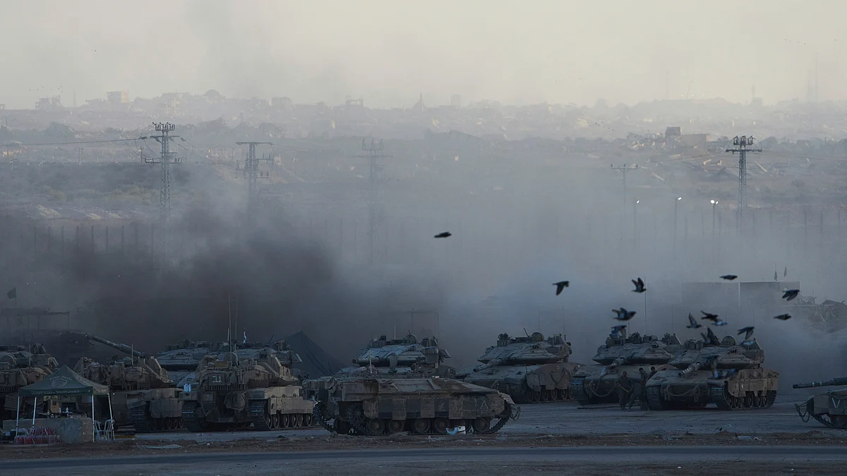 Israeli soldiers prepare a tank near the Gaza border amid escalating tensions