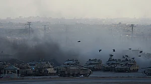 Israeli soldiers prepare a tank near the Gaza border amid escalating tensions