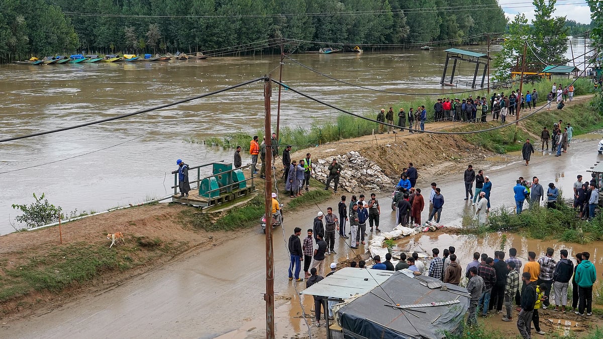 Locals gather at Pampore to witness the rain-fed river in spate