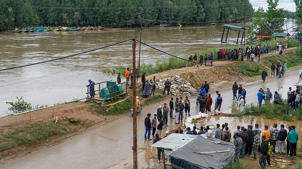 Locals gather at Pampore to witness the rain-fed river in spate