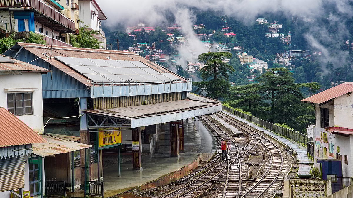 A man stands on the tracks as landslides halt Kalka-Shimla train services in Shimla.