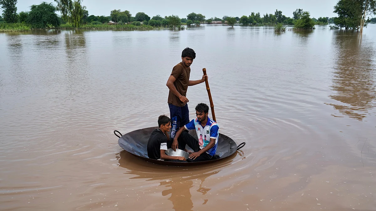 Villagers float across floodwaters on a jaggery pan-turned-raft in Jhang district