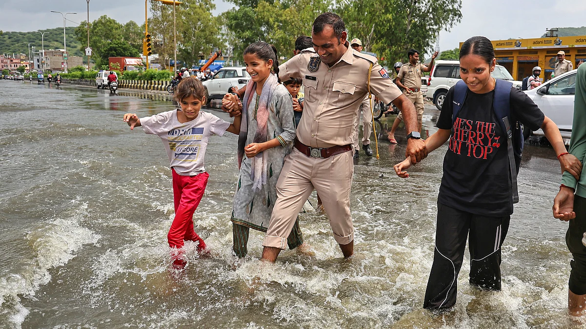 Pedestrians cross a waterlogged road in Jaipur
