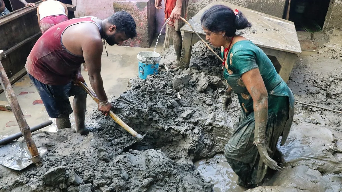 Residents of Yamuna Bazar clean slush from their houses after Yamuna waters receded in Delhi