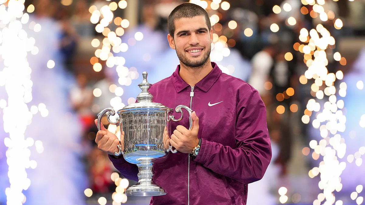 Carlos Alcaraz holds up the championship trophy