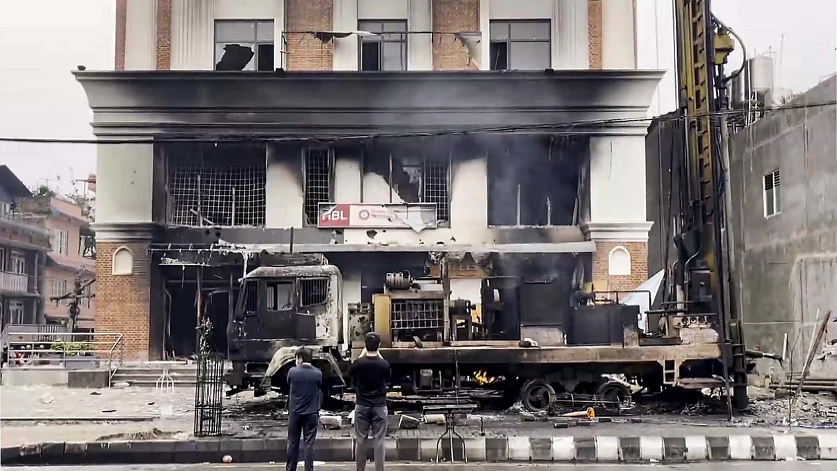 A charred building and vehicle following protests and clashes in Kathmandu. (Photo: PTI)