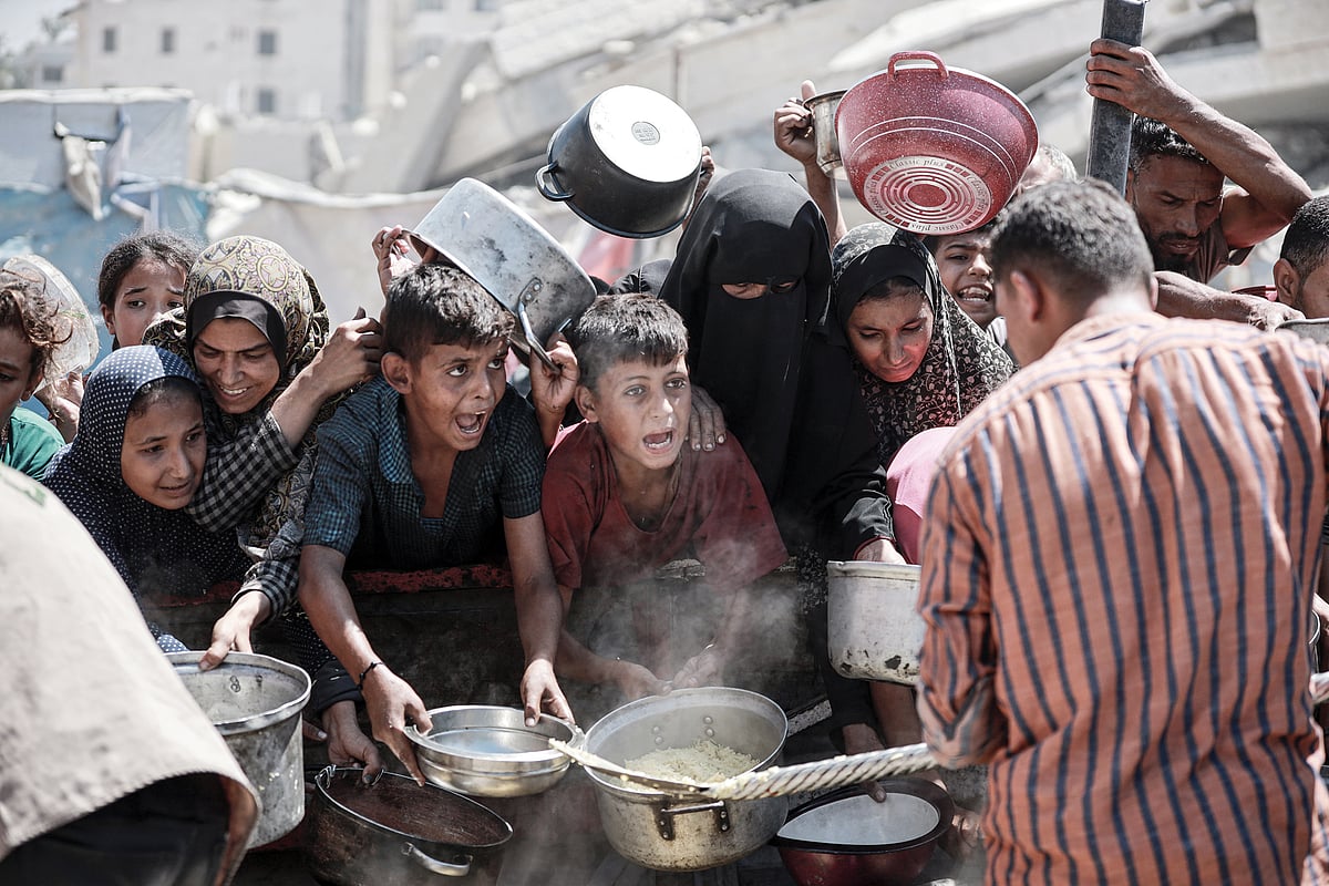 Starving Palestinians wait for food at an aid distribution point in Gaza