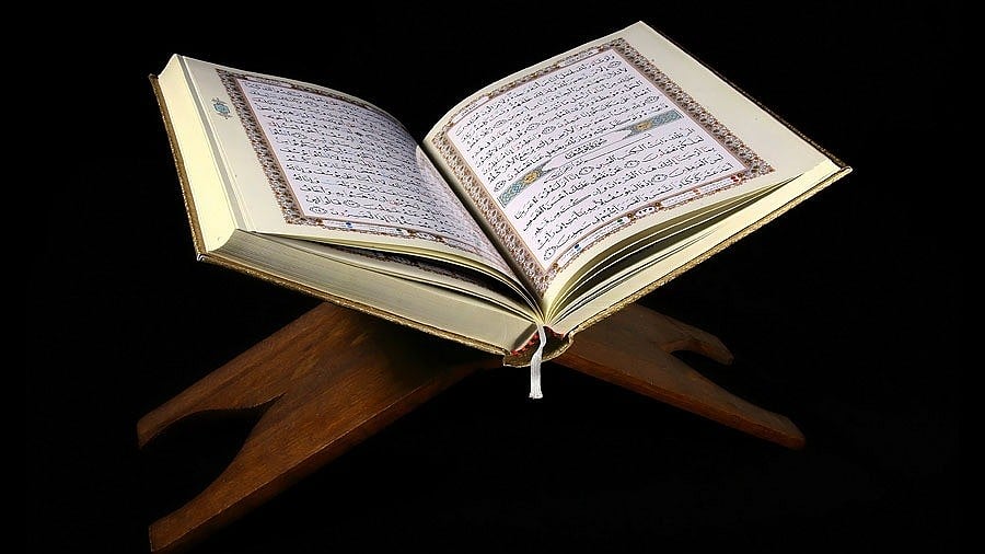 Image of an illuminated copy of the Quran placed open on a book stand