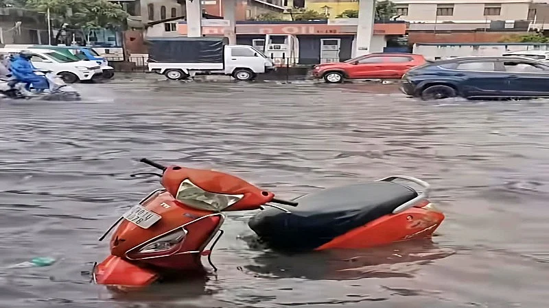 Vehicles struggle through a waterlogged street in Manipur.