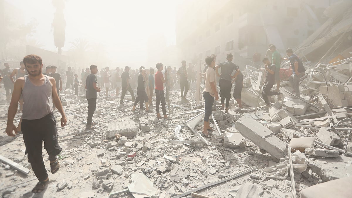Palestinians inspect the rubble of a building after an Israeli strike in Gaza City, 14 Sep