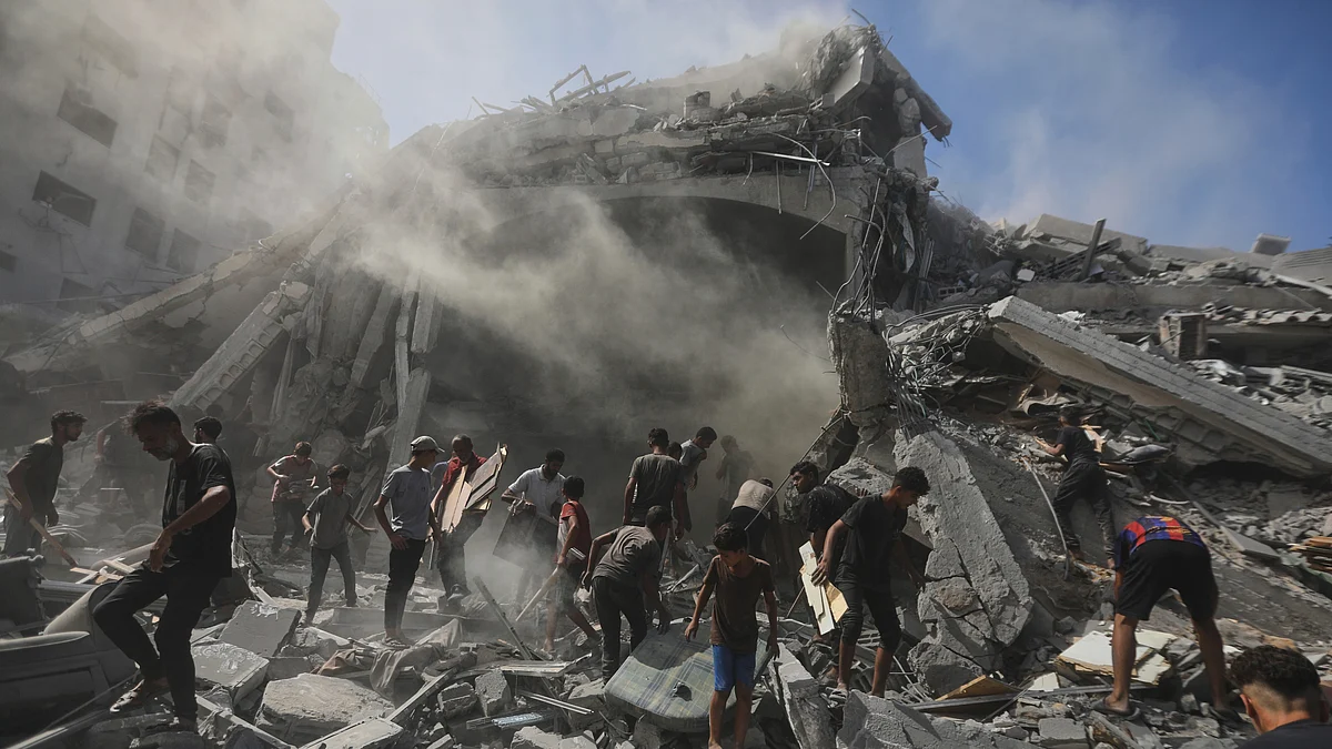 Palestinians search for wood to sell or use for cooking in the rubble of a building in Gaza City