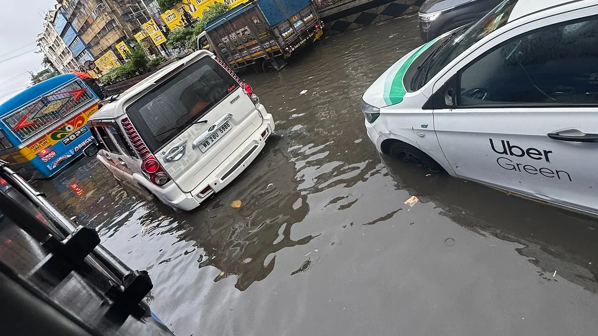 Vehicles passing through a flooded street in Kolkata after heavy overnight rain