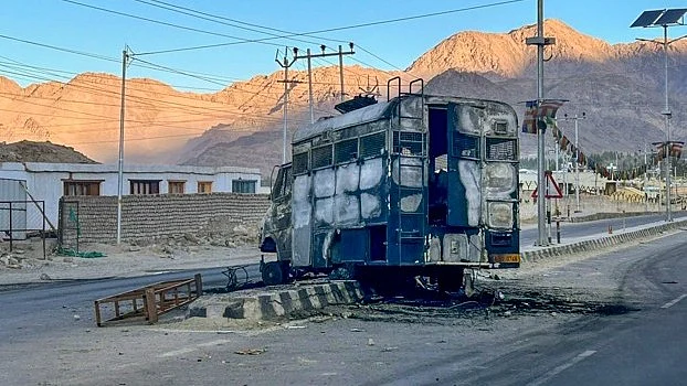 Charred remains of a vehicle lies in the middle of a deserted road in Leh