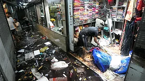 A shopkeeper clears the mess as floodwaters recede in Kolkata