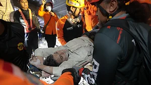 Rescuers pull out a survivor from the collapsed building