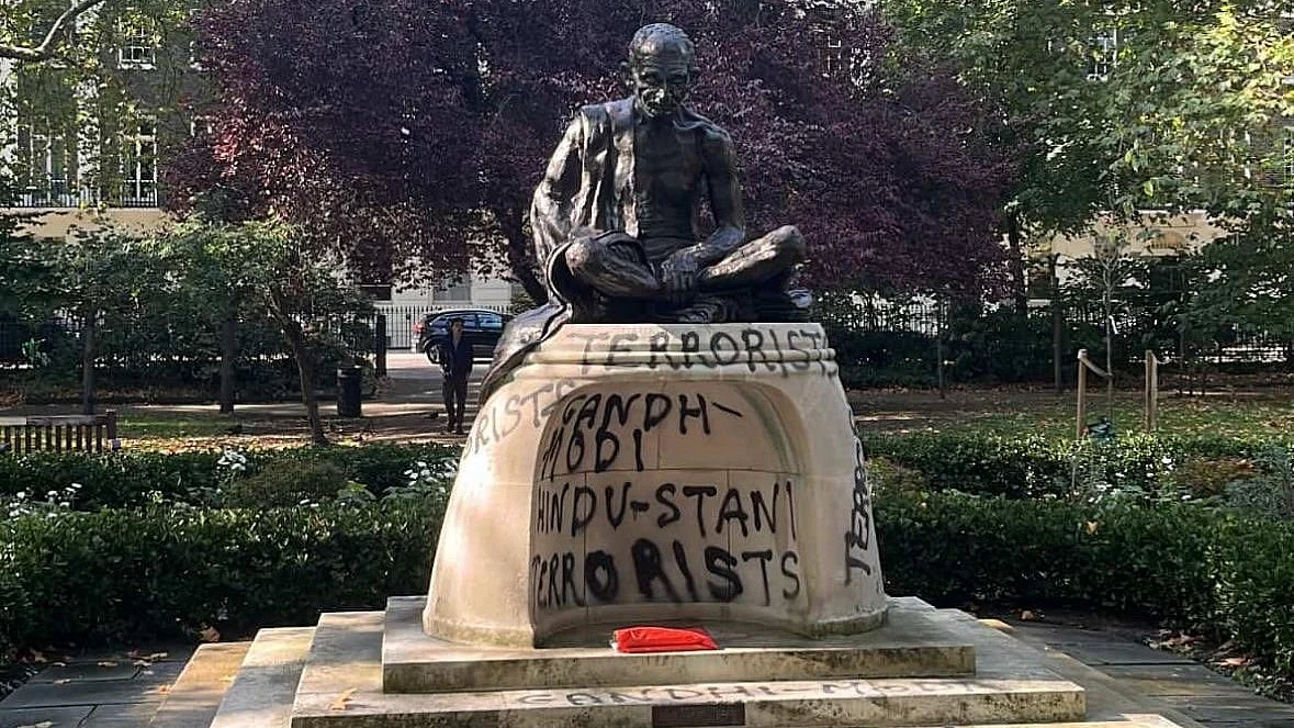 The Gandhi statue with graffiti sprayed at the plinth