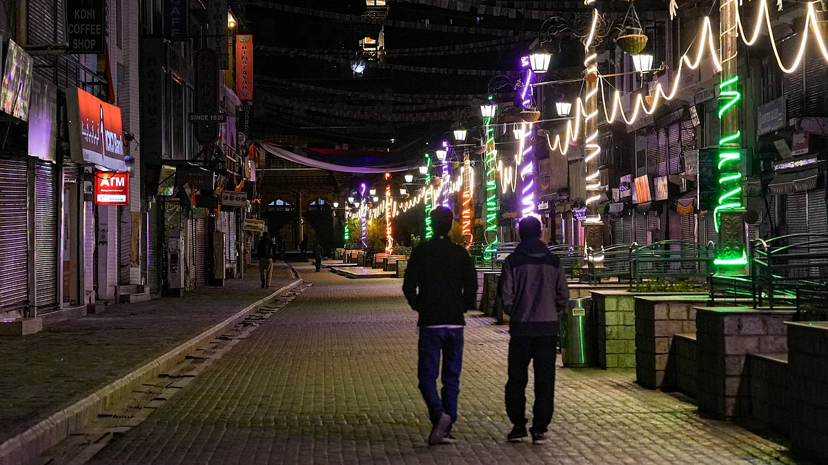 People walk past shuttered shops in Leh as curfew relaxation ends following recent unrest.