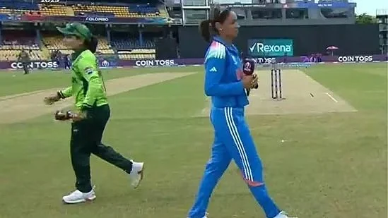 Harmanpreet Kaur (right) and Fatima Sana walk past each other after toss