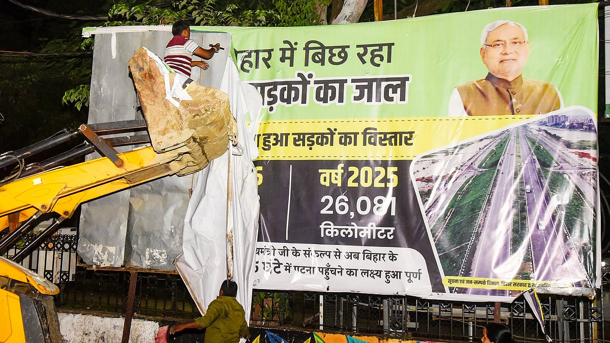 Workers remove a poster following the MCC in Patna, 6 Oct