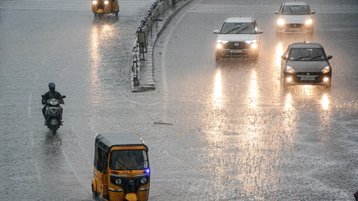 Chennai streets drenched as vehicles navigate heavy rainfall.