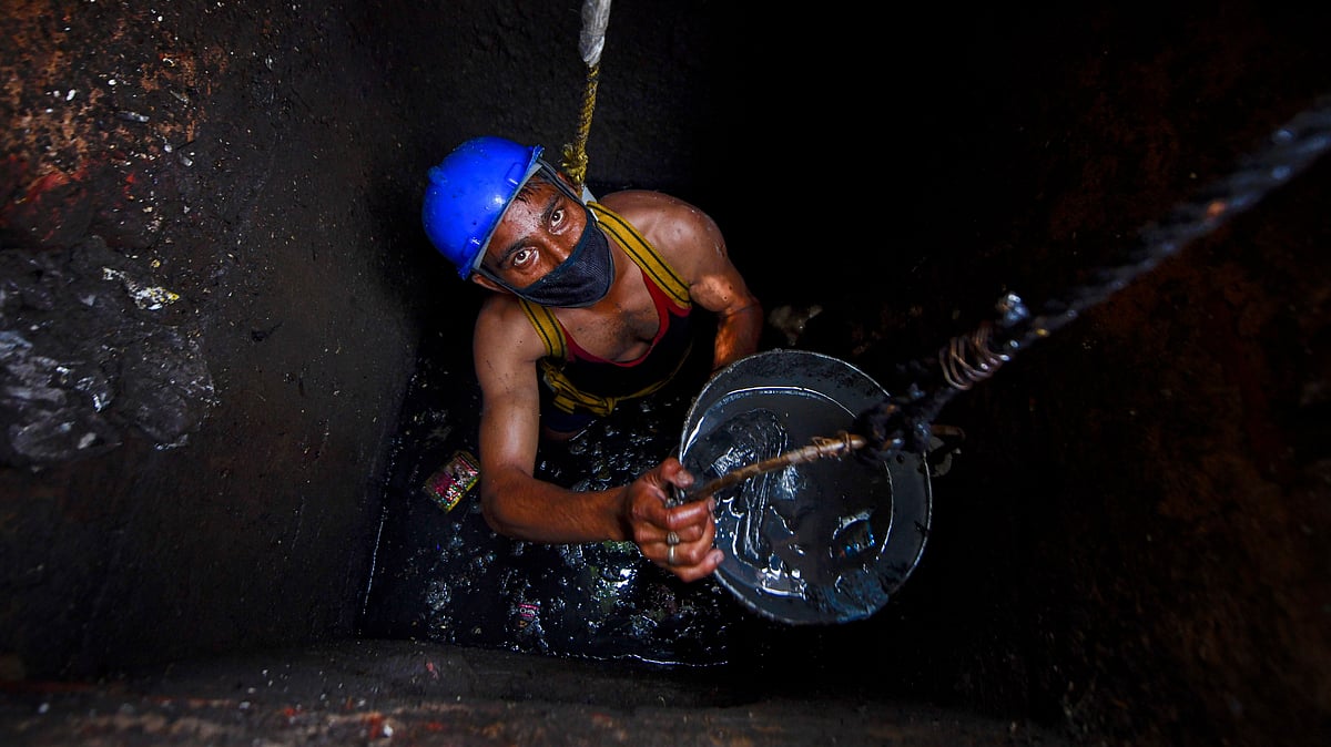 A sanitation worker cleans a manhole in Ghaziabad.
