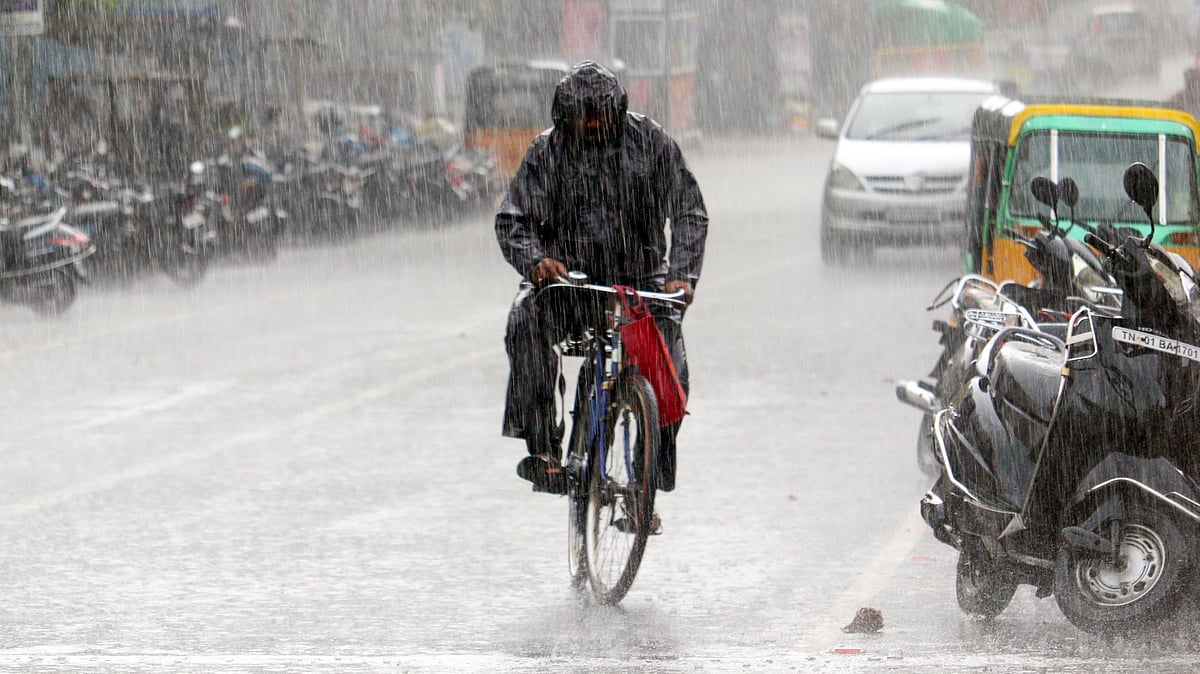 A cyclist pedals through rain-soaked streets in Chennai.