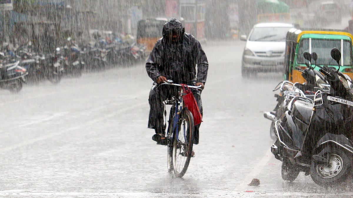 A cyclist pedals through rain-soaked streets in Chennai.