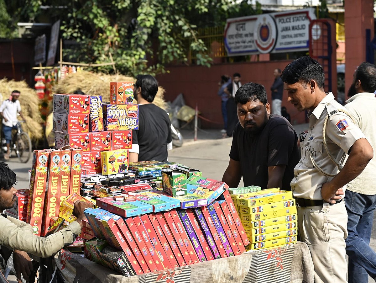 The enforcer’s choice: A policeman sifts through the wares in a fireworks vendor’s cart