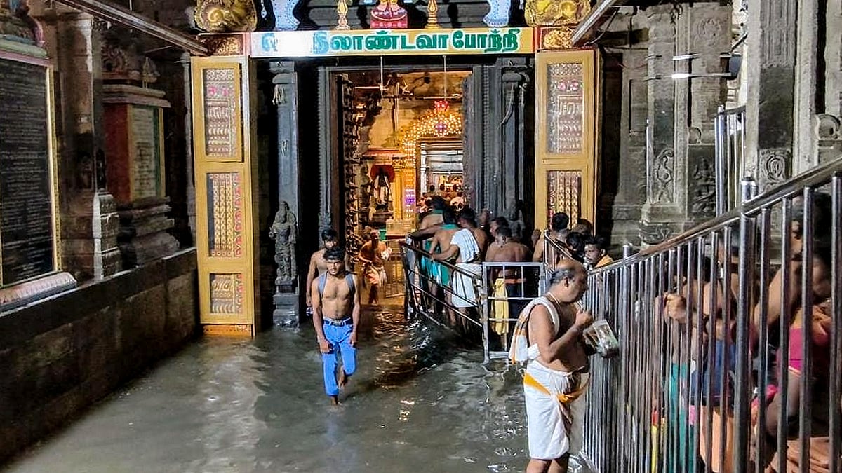Devotees wait in a queue amid waterlogged Thiruchendur Murugan Temple in Thiruchendur.
