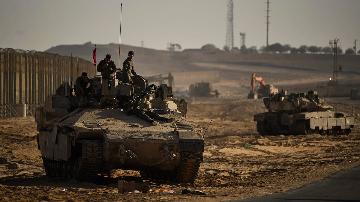 Israeli soldiers atop a tank near the border with Gaza