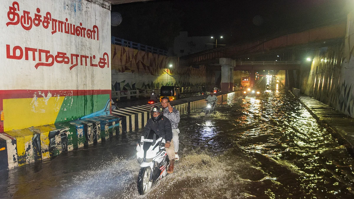 Commuters navigate a waterlogged underpass in Tiruchirappalli.