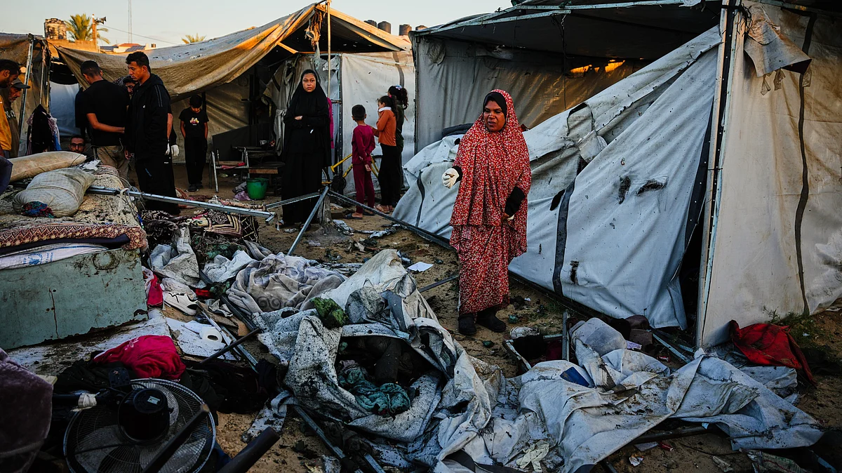 Displaced Palestinians inspect the damage after an Israeli army strike on their tent in Deir al-Balah