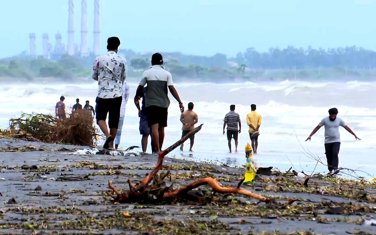 Debris strewn on the shore as people venture into the sea in Andhra.