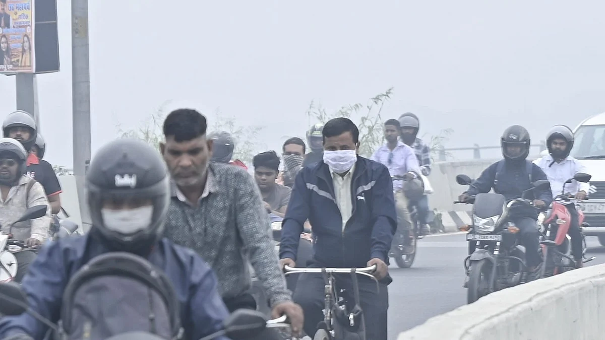 Commuters make their way through thick smog as air pollution grips Delhi.