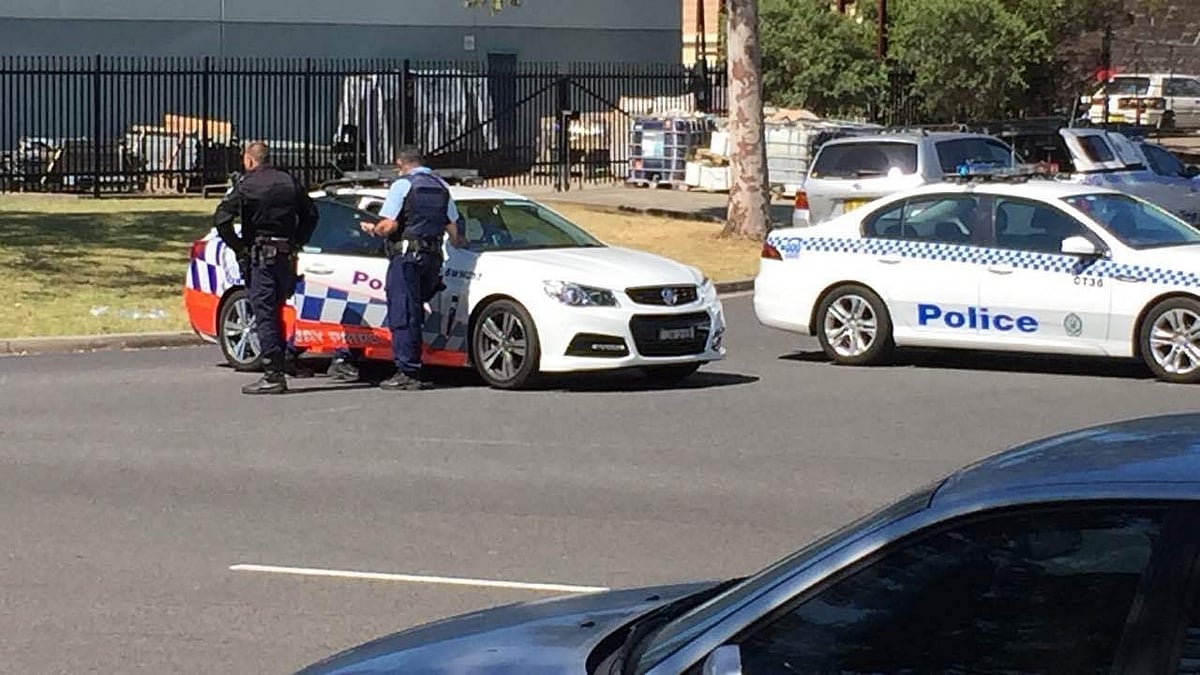 Police officers stand guard near the scene of a late-night shooting on Sydney’s outskirts.