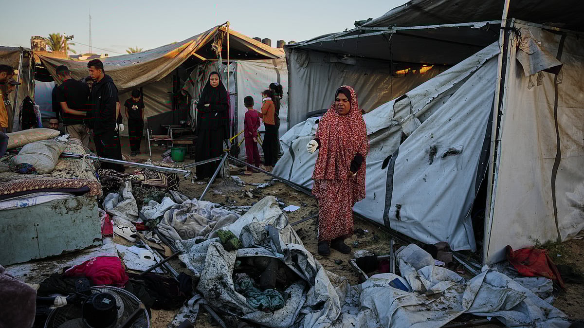 Displaced Palestinians survey the wreckage of their tent camp after an Israeli strike in Gaza Strip.
